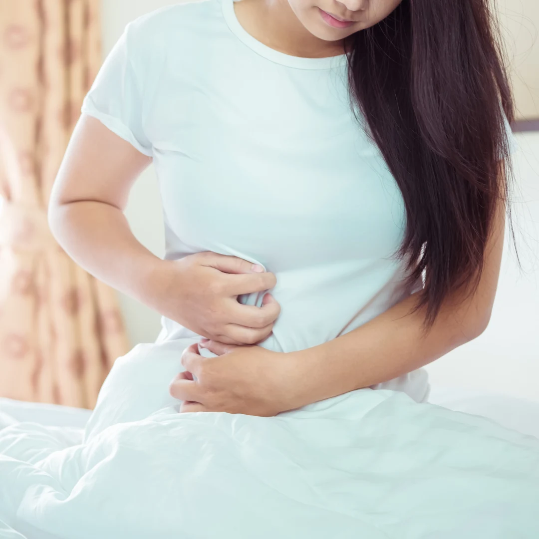 Woman holding her stomach because of leaky gut symptoms